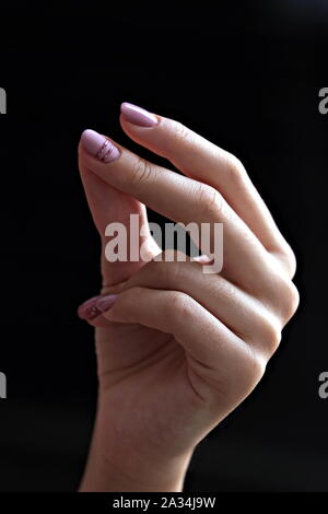 Close view of  the hand of a young woman snapping her fingers Stock Photo