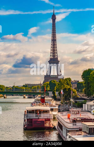 Nice portrait view of the iconic Eiffel Tower with ships anchored at the Port de Javel Haut at the river Seine in Paris on a nice day with a blue sky. Stock Photo