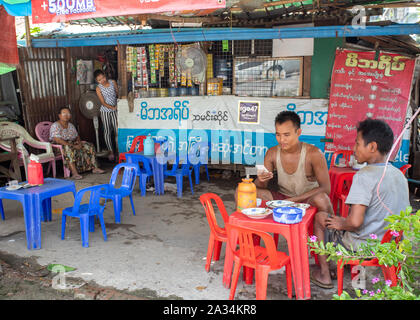 People having meal in traditional burmese reastuarant. Traditional street food restoran in Yangon, Myanmar. Stock Photo
