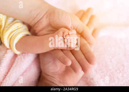 Family Baby Hands. Father and Mother Holding Newborn Kid.  Stock Photo