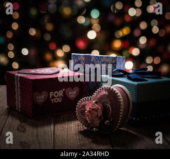 Gift boxes are on wooden plank under shinning light with colorful bokeh background