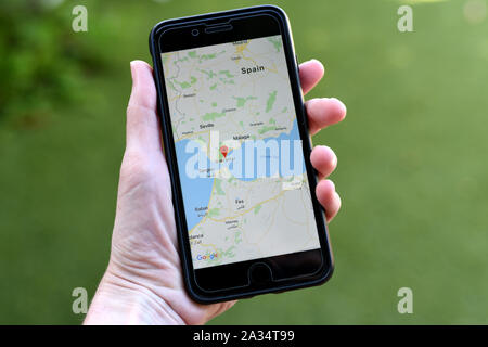 Gibraltar 04 October 2019: A hand holding an iphone showing the google maps app and focusing on the region of Gibraltar Stock Photo