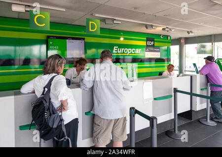 France Lyon 2019-06-18 Europcar car rental desk, employee register a rental contract for customers at Lyon Airport in France. Europcar has a fleet of Stock Photo