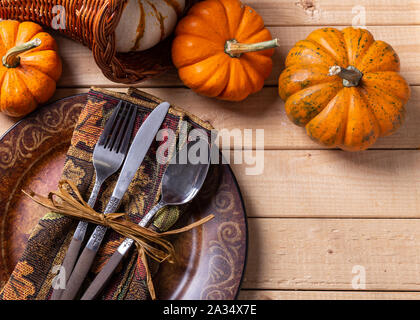 Overhead view of an utumn place setting and mini pumpkins on a rustic wooden table Stock Photo