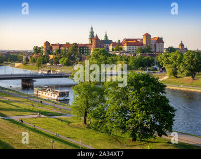 Krakow, Poland, with Wawel castle and cathedral, Vistula river, Podwawelski bridge, a restaurant on the  barge, trees and promenades in summer. Aerial Stock Photo