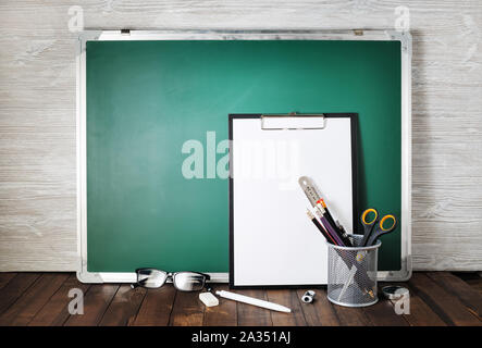 Photo of blank green blackboard and stationery. School supplies. Responsive design template. Stock Photo