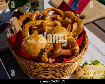Buns and pretzels. Basket with bread rolls and pretzels on an table. Stock Photo