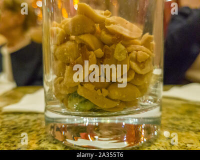Detail of full glass of peanuts on a table Stock Photo