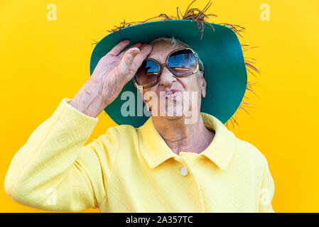 Funny grandmother portraits. Senior old woman dressing elegant for a special event. Concept about seniority Stock Photo