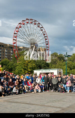 Audience watching street entertainment during the Edinburgh Fringe Festival on the The Mound area of the city centre. Stock Photo