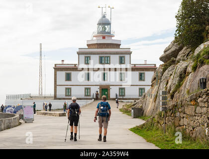 Walkers approaching Cape Finisterre Lighthouse at the end of the Camino Finisterre, and additional section of the Camino de Santiago. Stock Photo