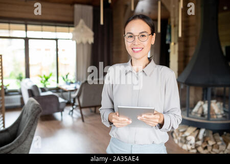 Young successful owner of modern restaurant or cafe holding touchpad Stock Photo