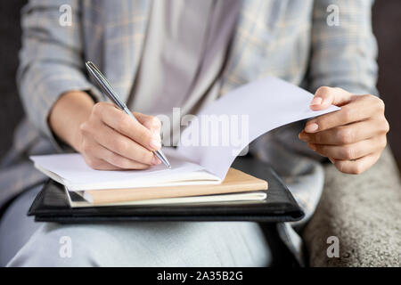 Contemporary young teacher with pen checking paper of one of students Stock Photo