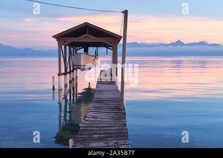 A boat is suspended above the Caribbean Sea on the island of Utila in Honduras Stock Photo