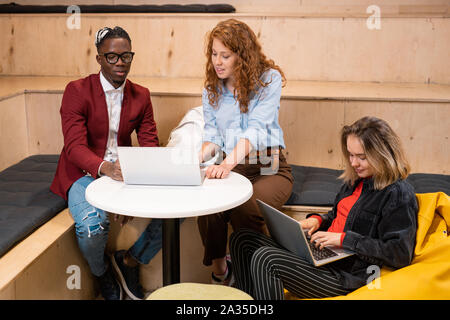 Clever intercultural students in casualwear making presentation for conference Stock Photo