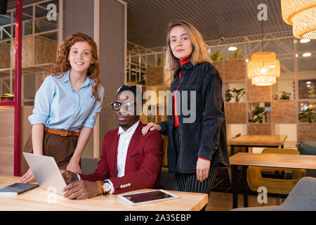 Small group of young successful intercultural employees looking at you Stock Photo