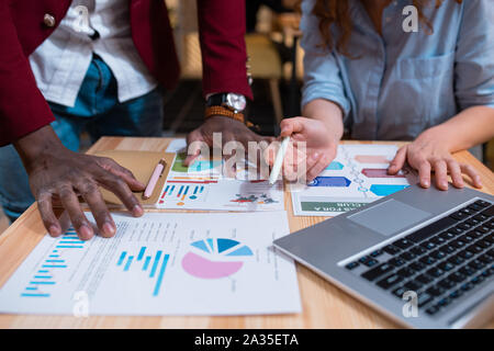 Hands of young multicultural employees over financial papers during discussion Stock Photo