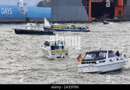 Hamburg, Germany. 05th Oct, 2019. Boats are driving in a protest action with banners with the inscription: 'Dove Elbe save' a parade before the landing bridges in the port of Hamburg. The demonstrators fear that the Dove Elbe at the Tatenberg lock could open towards the northern Elbe and become a tidal river with ebb and flow. Credit: Georg Wendt/dpa/Alamy Live News Stock Photo