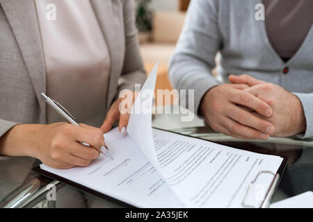 One of business partners putting signature on last page of financial contract Stock Photo