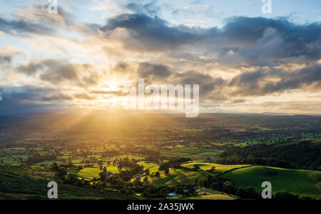 Sun breaking through clouds over the Vale of Clwyd seen from Moel Llys Y Coed and Moel Arthur in the Clwydian Range. Stock Photo