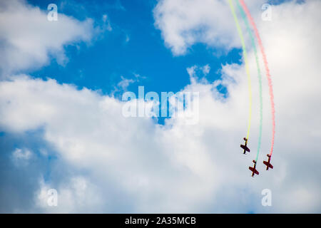 Aerobatics, air show. Aircraft team performing in the sky with old airplanes and drawing drawing Lithuanian flag, white clouds and blue sky Stock Photo