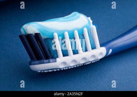 toothbrush toothpaste on blue background Stock Photo