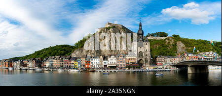 Dinant, Namur / Belgium - 11 August 2019: panorama view of the small town of Dinant on the Maas river with the historic citadel and cathedral on the r
