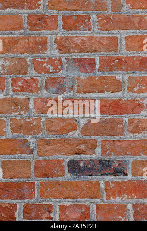 Ful frame image of a red brick wall with one black brick. Stock Photo