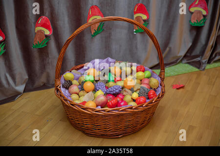 Apples, plums and a mountain ash in a basket, top view. Table-still life. Fresh juicy citrus fruits in a basket on a wooden background . Basket and Stock Photo