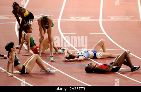 Athletes rest on the track after competing in the Women's 1500 Metres Final during day nine of the IAAF World Championships at The Khalifa International Stadium, Doha, Qatar. Stock Photo