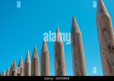 wooden fence made of sharpened wood poles - protective wall Stock Photo