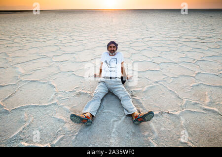 Man seated on a salt lake. Stock Photo
