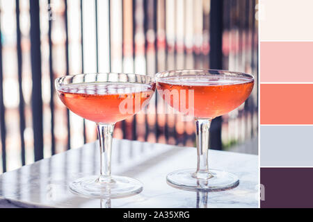 Two crystal stemmed glasses with rose wine on marble table outdoors in a cafe. Color swatch Stock Photo