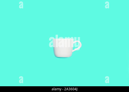 White cup for coffee on mint green blue color background. Pop art minimal flat lay style design, creative concept. Top view. Copy space. Stock Photo