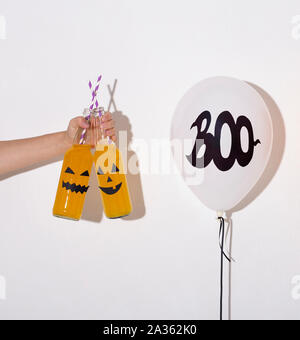Woman holding yellow Halloween cocktails in hand Stock Photo
