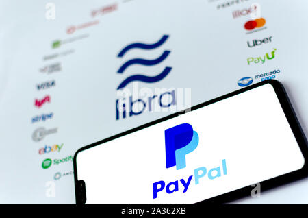 The Libra Association logo on paper brochure and PayPal logo on the smartphone screen. Illustrative for the news that PayPal exits the Association. Stock Photo