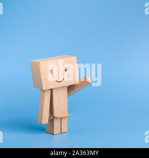 Funny toy cardboard robot on blue background Stock Photo