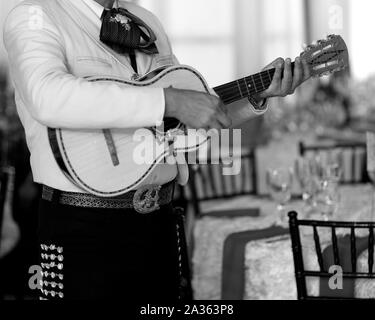 photo of mariachi man wearing traditional outfit and holding guitar instrument Stock Photo