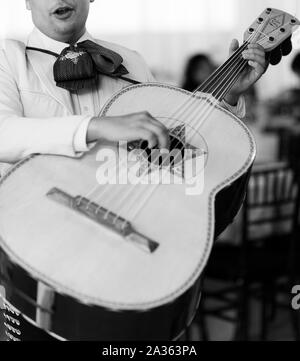 photo of mariachi man wearing traditional outfit and holding guitar instrument Stock Photo