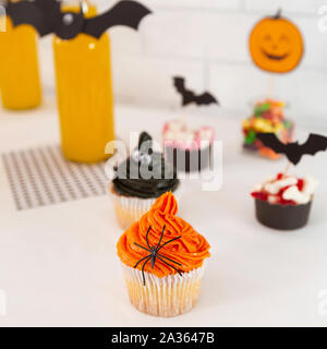 Yellow drinks and tasty cupcakes with decorations on table Stock Photo