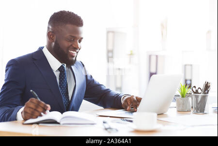 Cheerful young manager making market research online Stock Photo