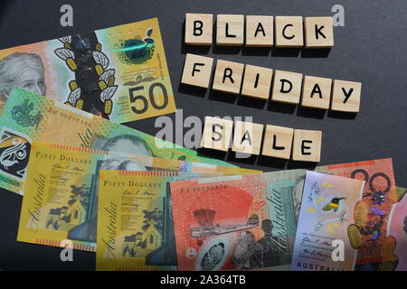 Black Friday Sale in 3d wooden alphabet letters with high denomination Australian dollar banknotes Stock Photo