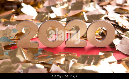 Close up of 2020 wooden text in confetti on red background Stock Photo