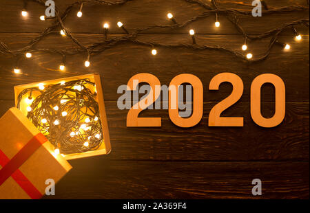 Garland with lights, gift box and 2020 concept on wood Stock Photo
