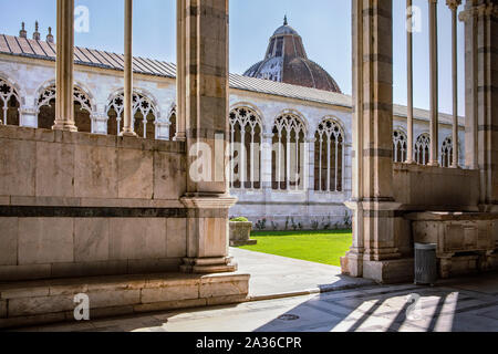 View from gallery on internal patio, Camposanto Monumentale di Pisa. Monumental Cemetery, Interior courtyard. Visible baptistery dome. Tuscany, Italy Stock Photo