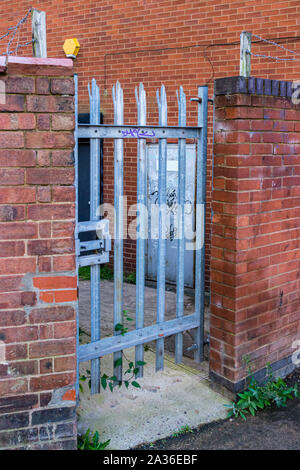 A padlocked security gate at the rear of a commercial premises Stock Photo