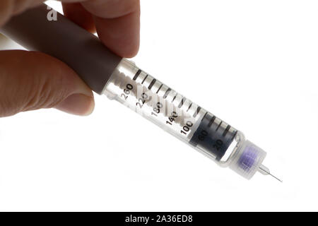 Close up of hand holding insulin pen on white bakground. Stock Photo