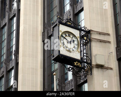 A ornate clock on the side of the Old Evening Standard Building in London Stock Photo