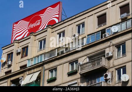 Bucharest, Romania -  September 29, 2019: A very large logo of Coca-Cola soft drink manufacturer is displayed on the top of a block of flats, in Bucha Stock Photo