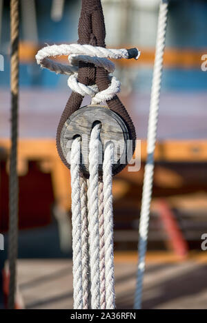 Old vintage pulley system with rigging ropes on a sailboat or tall ship in a close up view Stock Photo